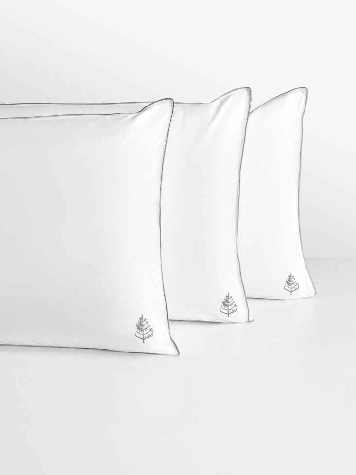 Three white pure down pillows with a small Four Seasons Logo on a light gray background.