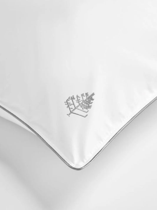 White pillow with a Four Seasons logo on a white background