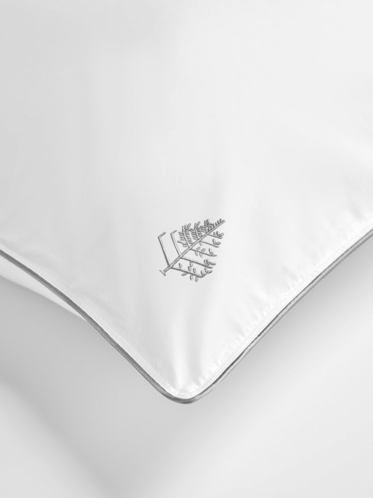White pillow with a Four Seasons Logo on a white background.