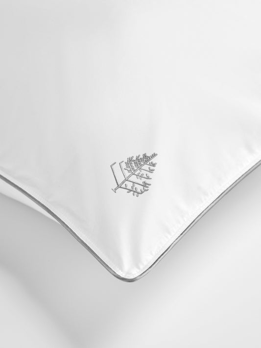 White pillow with a Four Seasons Logo on a white background.