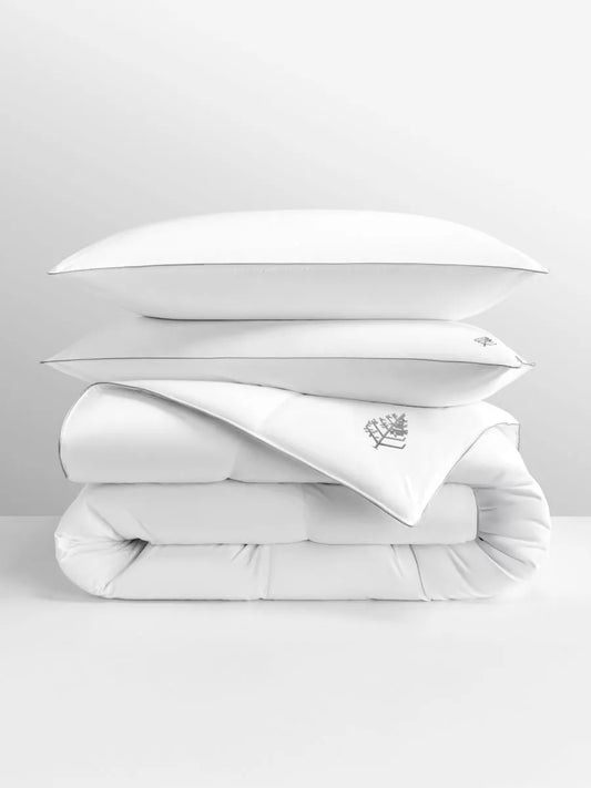 Stack of white bedding with a Four Seasons Logo on a light gray background