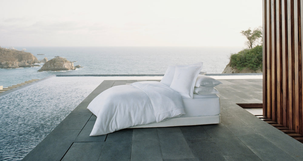 Four Seasons signature bed by the ocean in a beautiful hotel setting