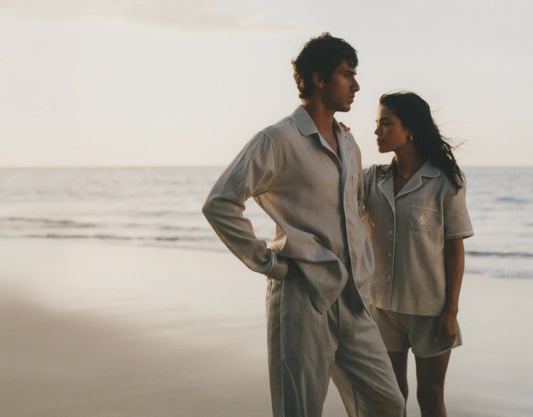 Two people standing on a beach wearing Four Seasons pajama sets.