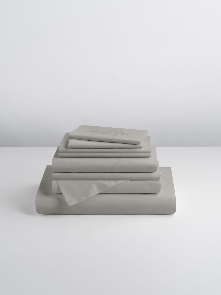 A set of Spanish Slate-colored sheets, folded into perfect rectangles and stacked on a flat surface.