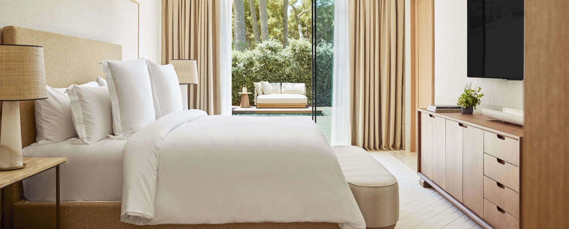 Modern bedroom with a bed, side tables, and a television.