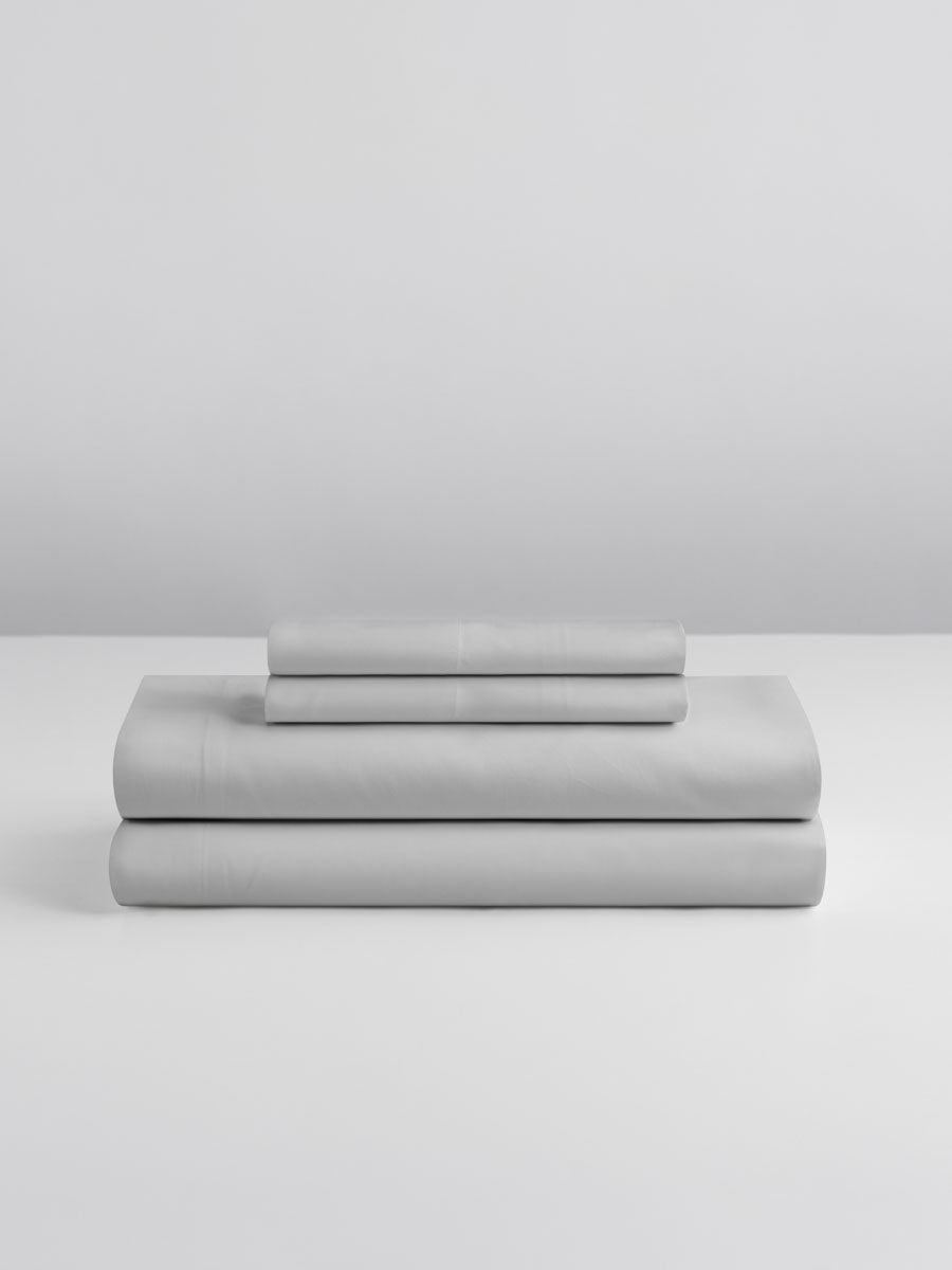 A set of Turkish Silver-colored sheets, folded into perfect rectangles and stacked on a flat surface.