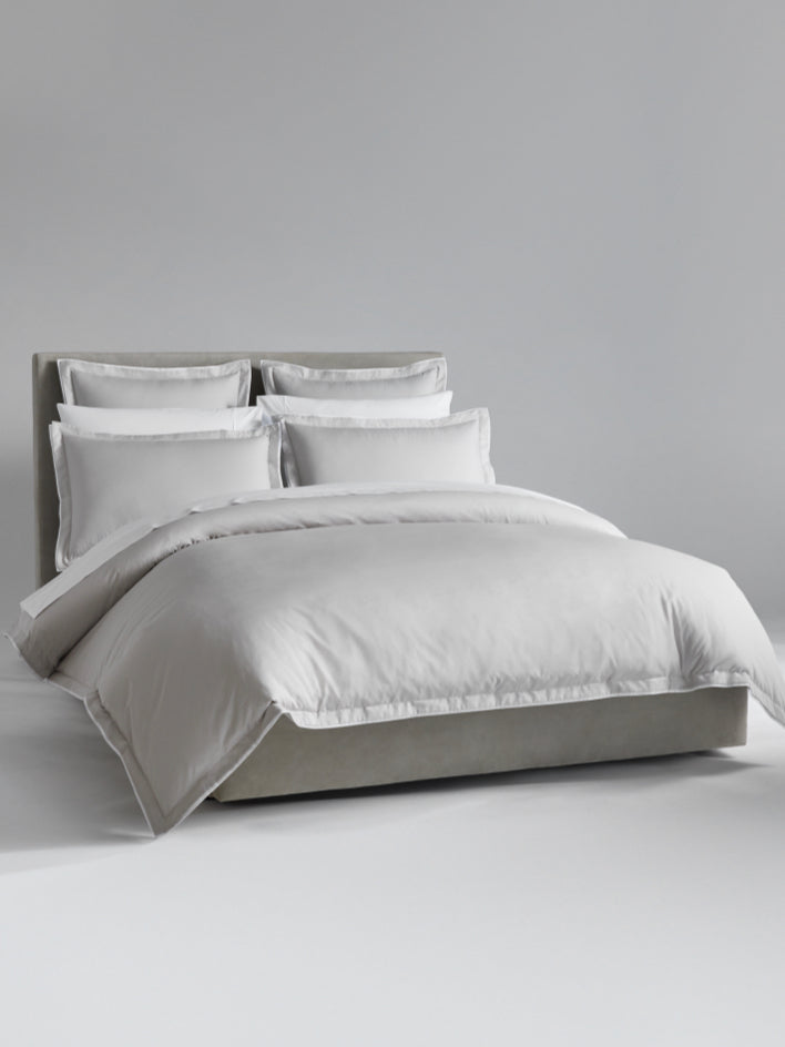 The bed is dressed with Turkish Silver/Signature White bedding and has several pillows arranged at the headboard. - {{Turkish Silver/Signature White}}