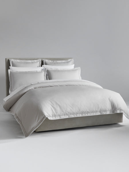 The bed is dressed with Signature White bedding and has several pillows arranged at the headboard.