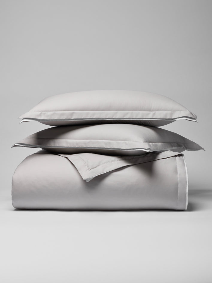 Two pillows carefully placed on top of a sheet. - {{Turkish Silver/Signature White}}