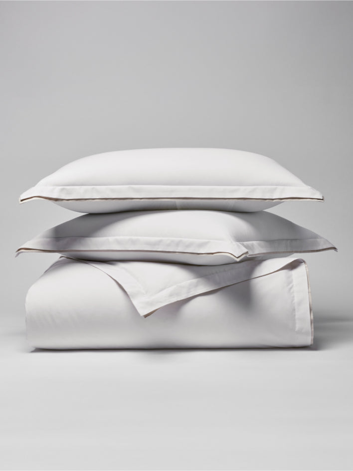 Two pillows carefully placed on top of a sheet. - {{Signature White/Balinese Pearl}}