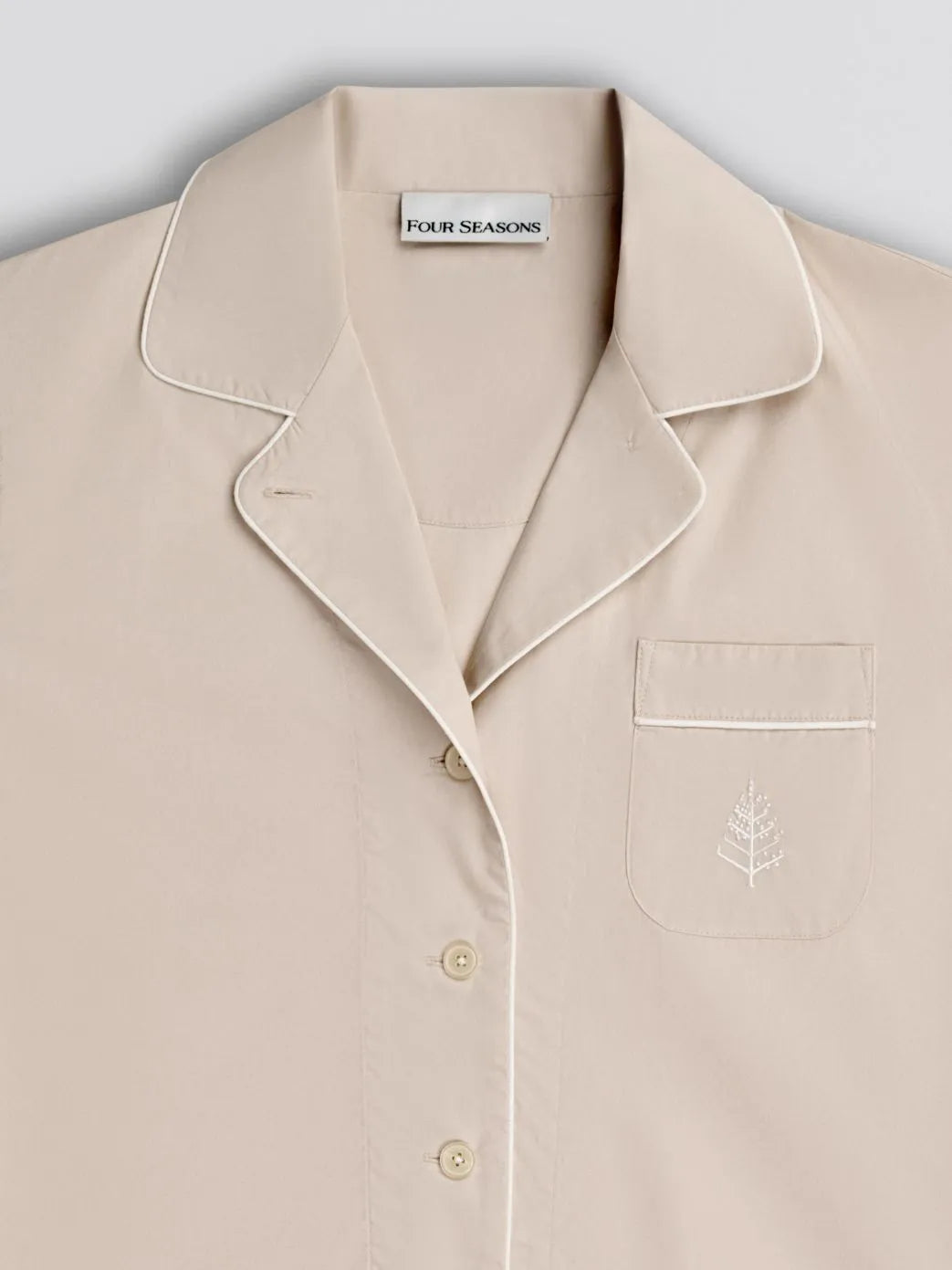 Balinese pearl pajama shirt with collar and pocket detail, featuring 'Four Seasons' branding on front logo with white piping trim. {{Balinese Pearl}}