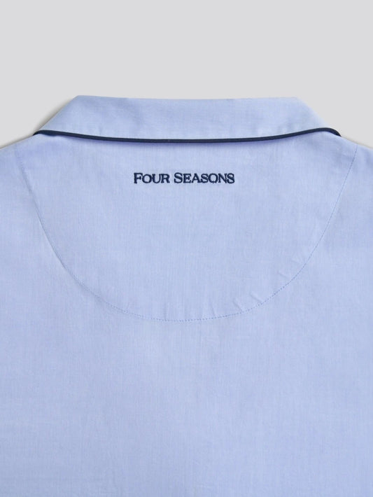 Light blue pajama shirt with 'FOUR SEASONS' text on the collar against a light gray background.