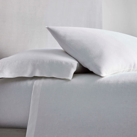 Acacia Sheet Set in Signature White —linen flat and fitted sheet with modern hem, styled on bed with matching pillowcases. - {{Signature White}}
