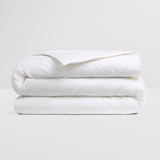 All Seasons Duvet — premium white down insert, neatly folded on a neutral surface for year-round comfort.