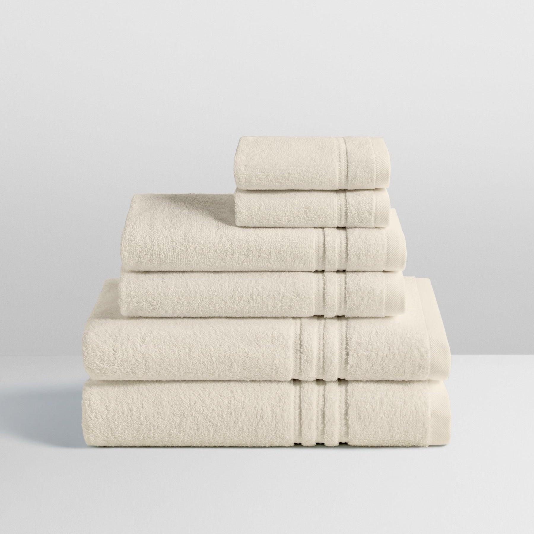 6-piece colored towel set in Balinese Pear, finished with a patterned dobby border. - {{Balinese Pearl}}