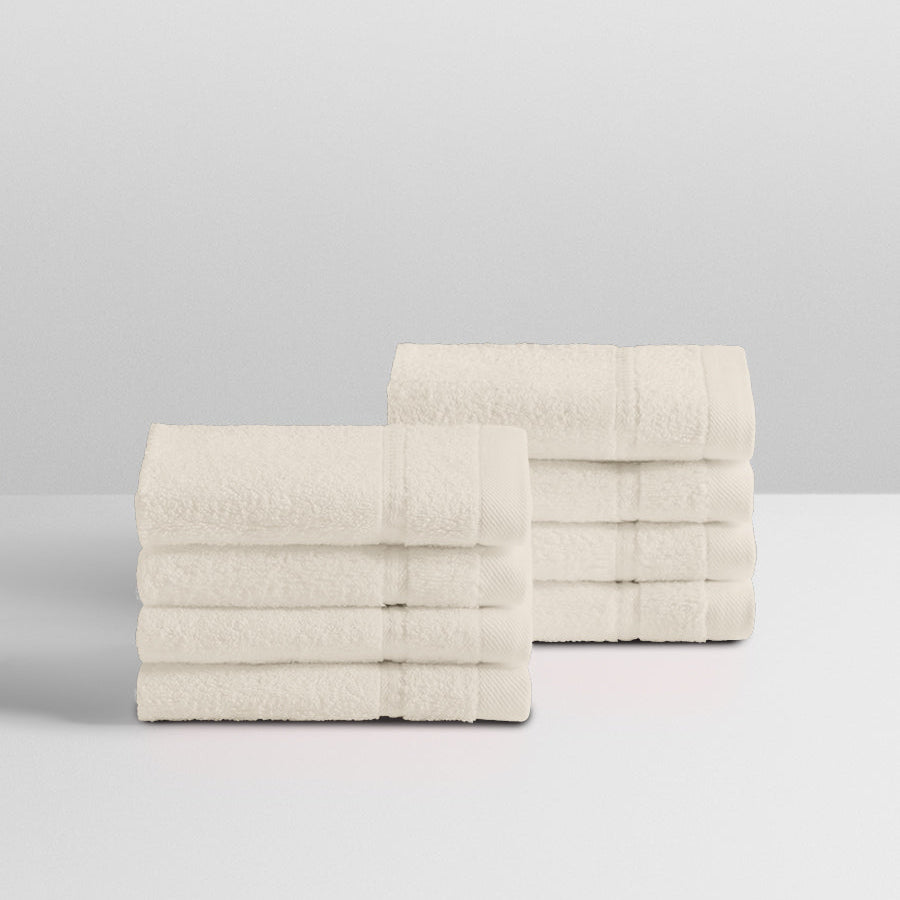 A stack of eight soft, “Balinese Pearl” colored clothes neatly folded on a white surface. - {{Balinese Pearl}}