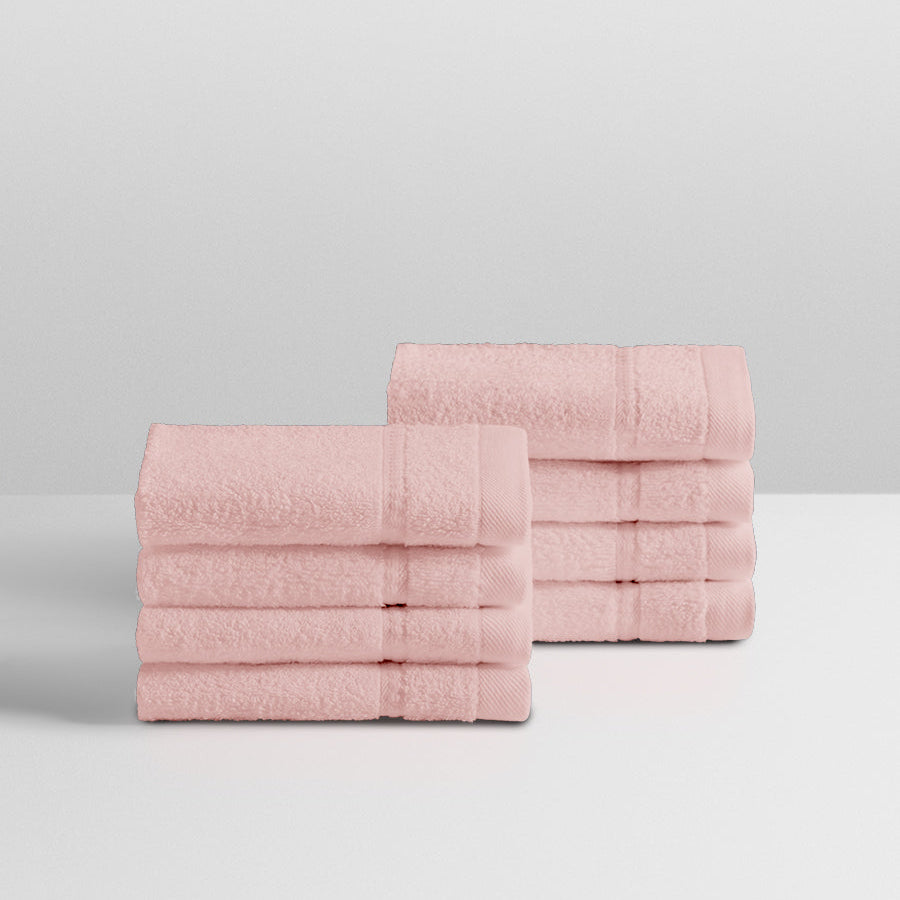 A stack of eight soft, “Kyoto Blush” colored clothes neatly folded on a white surface. - {{Kyoto Blush}}