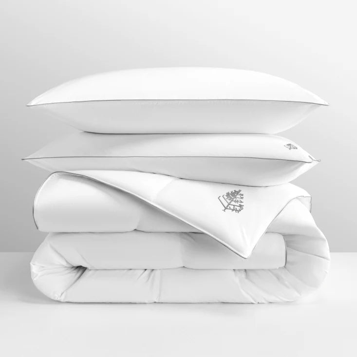 White pure down duvet bedding with a pure down pillows stacked on top with a Four Seasons Logo on a light grey background.
