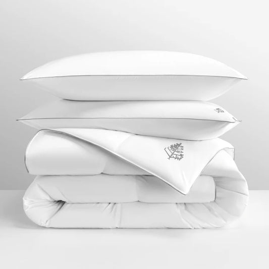 White pure down duvet bedding with a pure down pillows stacked on top with a Four Seasons Logo on a light grey background.