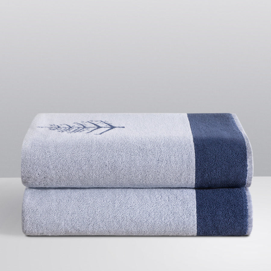 Two folded Resort Towels in a "Maldivian Atoll" color, featuring an embroidered Four Seasons logo. The towels are stacked on a white surface. - {{Maldivian Atoll}}