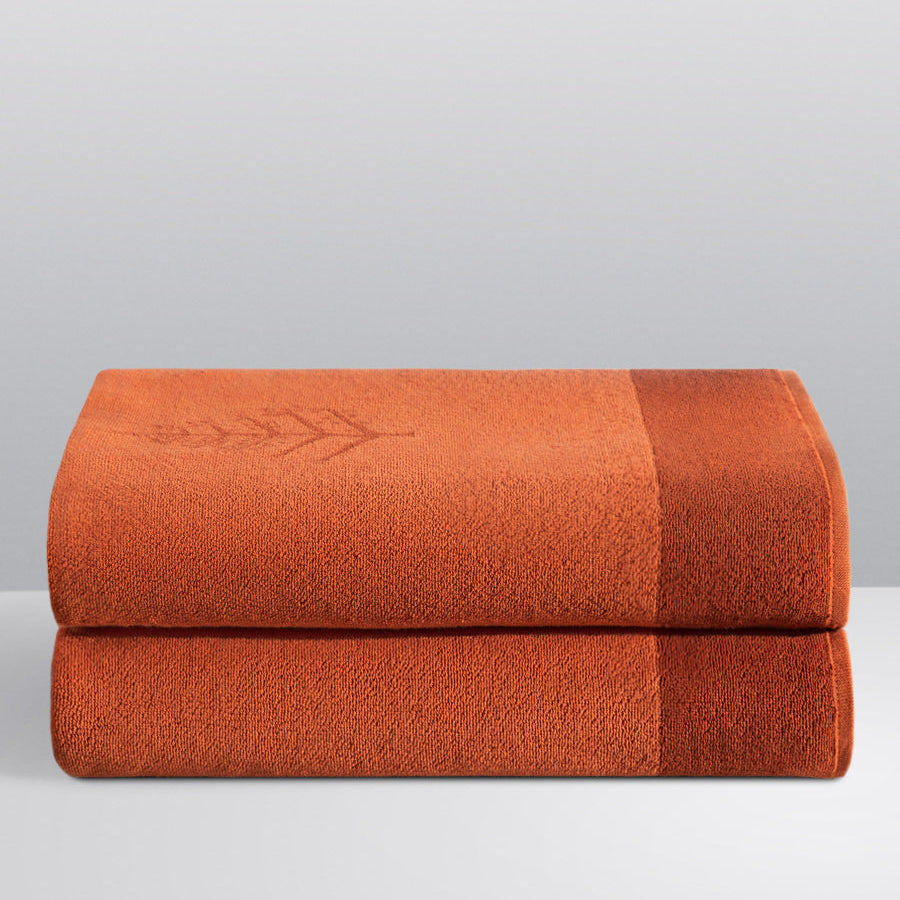 Two folded Resort Towels in a "Sicilian Dawn" color, featuring an embroidered Four Seasons logo. The towels are stacked on a white surface. - {{Sicilian Dawn}}