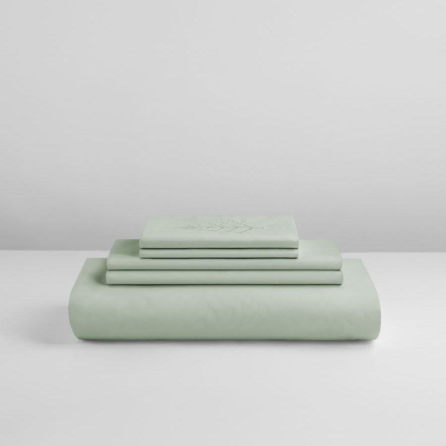 Florentine Sage duvet cover set stacked: folded duvet and shams; top piece with tone-on-tone logo store embroidery. {{Florentine Sage}}