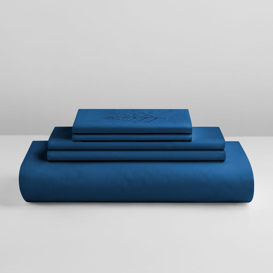 Riviera Navy duvet cover set stacked: folded duvet and shams; top piece with tone-on-tone logo store embroidery. {{Riviera Navy}}