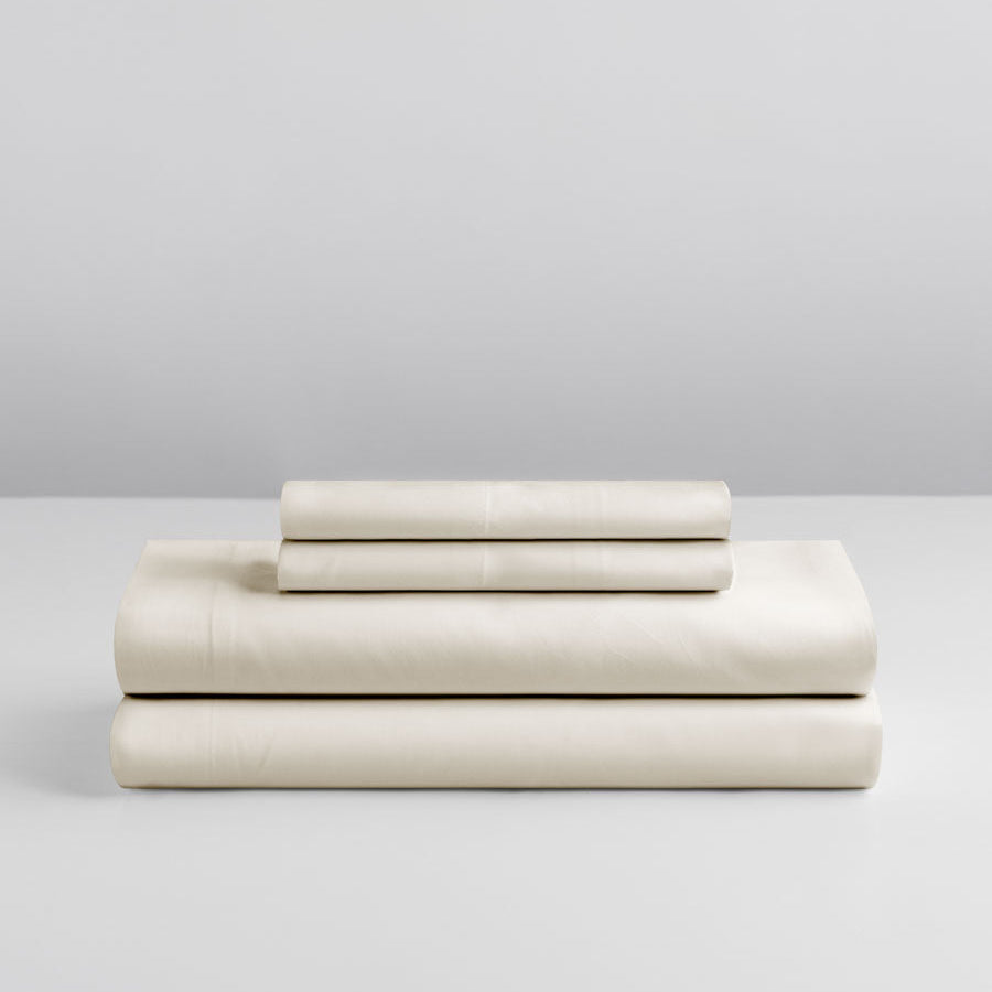 Four Seasons Signature Sheet set folded in Balinese Pearl on a grey background. {{Balinese Pearl}}