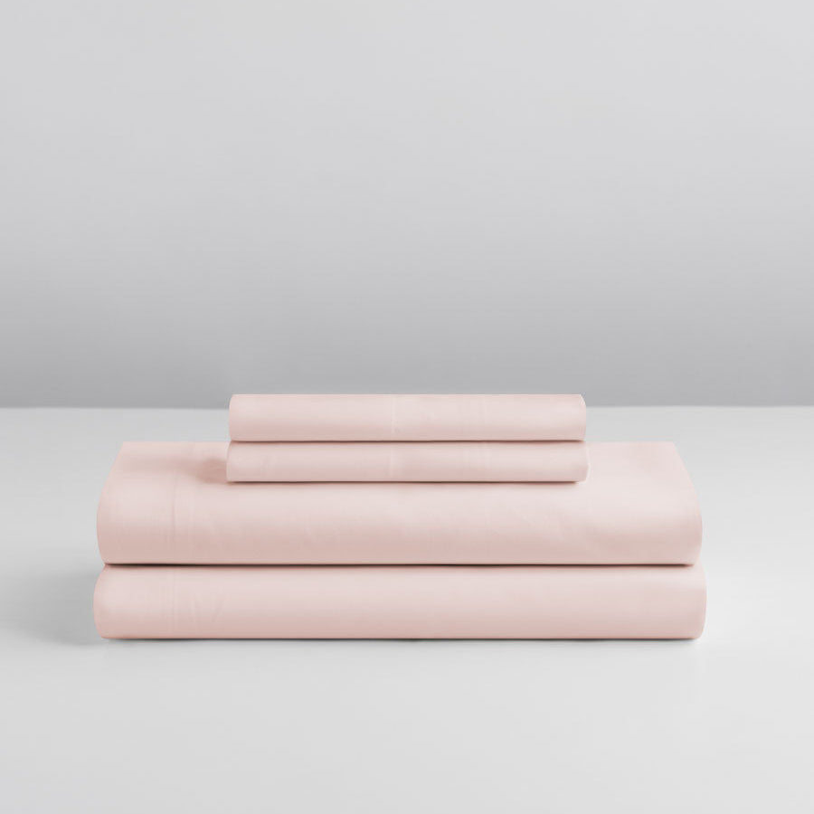 Four Seasons Signature Sheet set folded in Kyoto Blush on a grey background. {{Kyoto Blush}}
