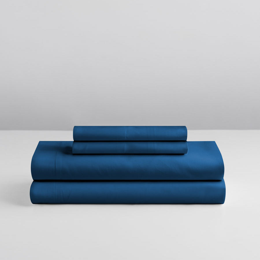 Riviera Navy sheet set stacked: folded fitted and flat sheet, two pillowcases. {{Riviera Navy}}
