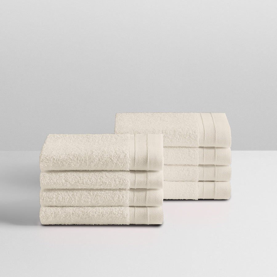A stack of eight soft, “Balinese Pearl” colored clothes neatly folded on a white surface. - {{Balinese Pearl}}