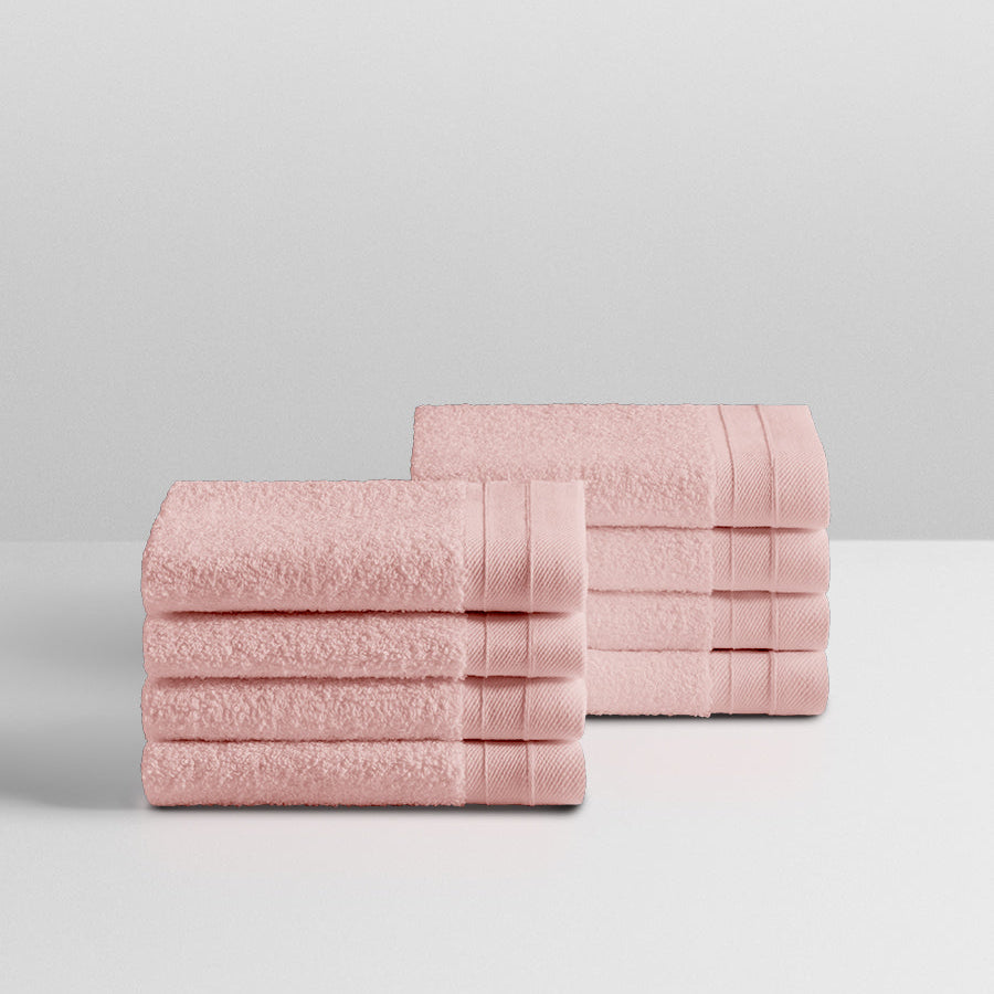 A stack of eight soft, “Kyoto Blush” colored clothes neatly folded on a white surface. - {{Kyoto Blush}}
