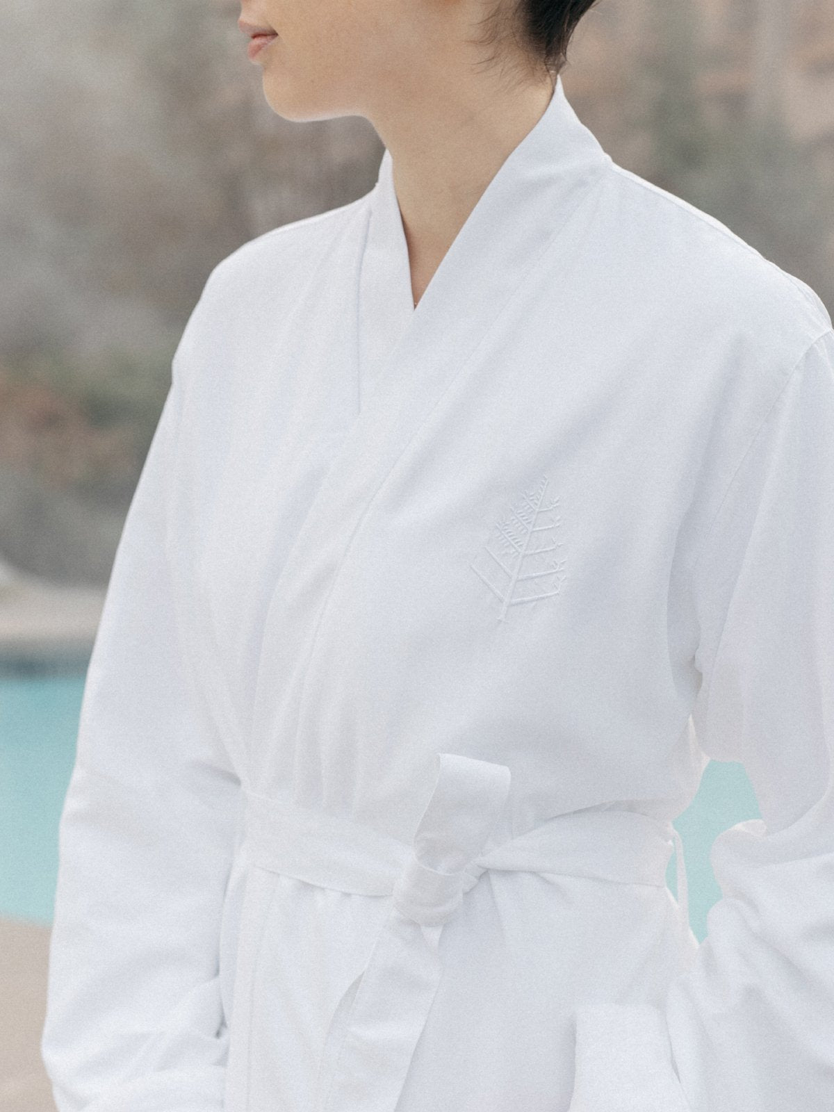 A person wearing a comfortable spa robe with the store's logo carefully embroidered.