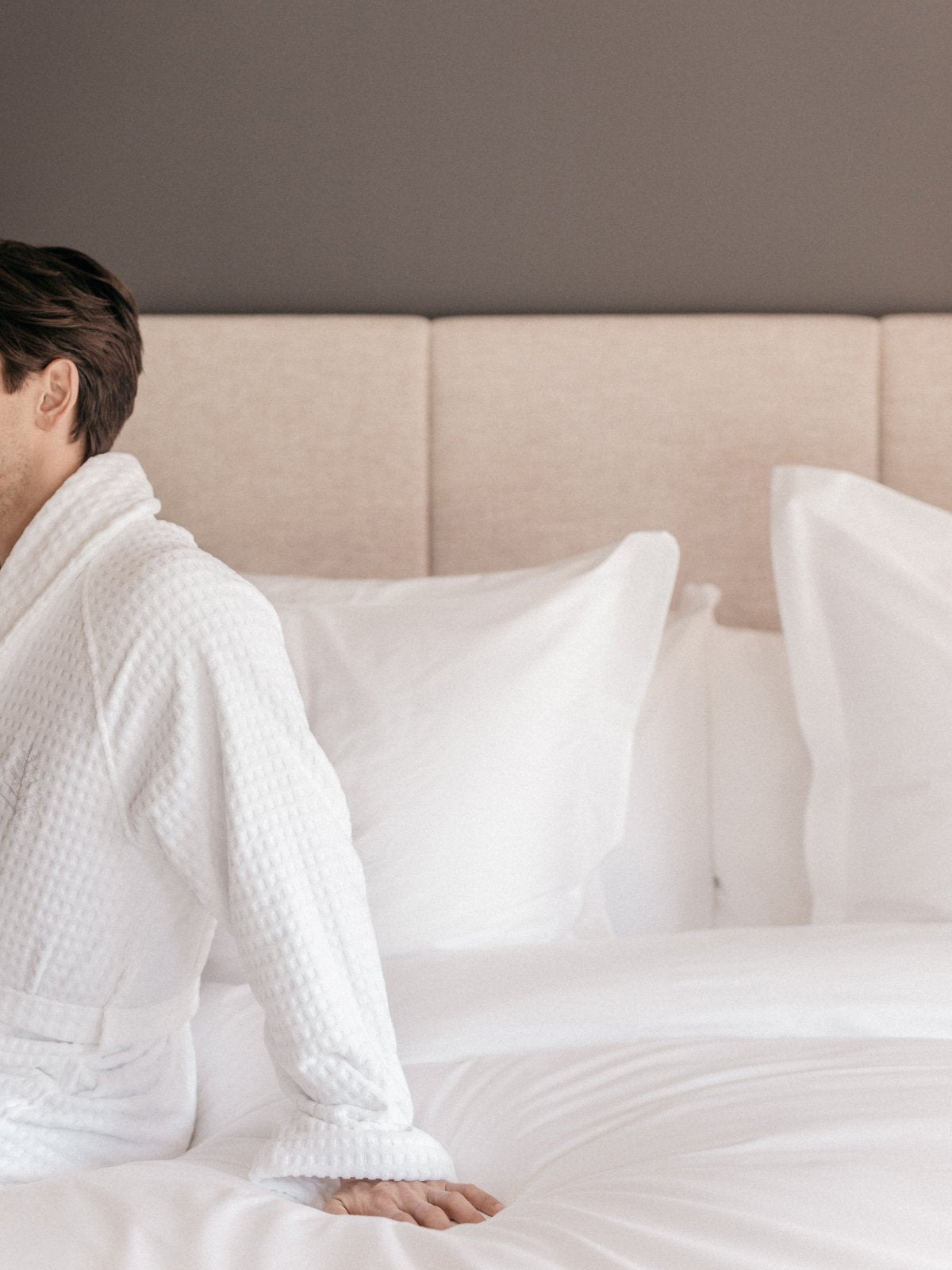 A person on a bed wearing a bathrobe, demonstrating comfort.