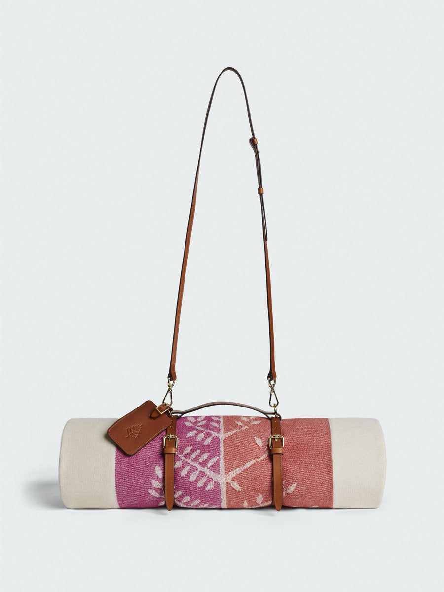 Four Seasons Leather Travel Strap with a blanket attached and a removable shoulder strap.
