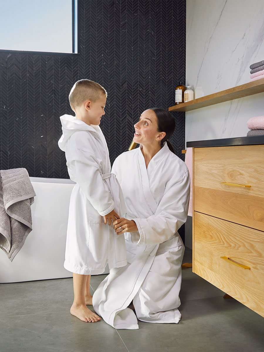 Close-up view of two people, a child and a woman, wearing comfortable bathrobes.